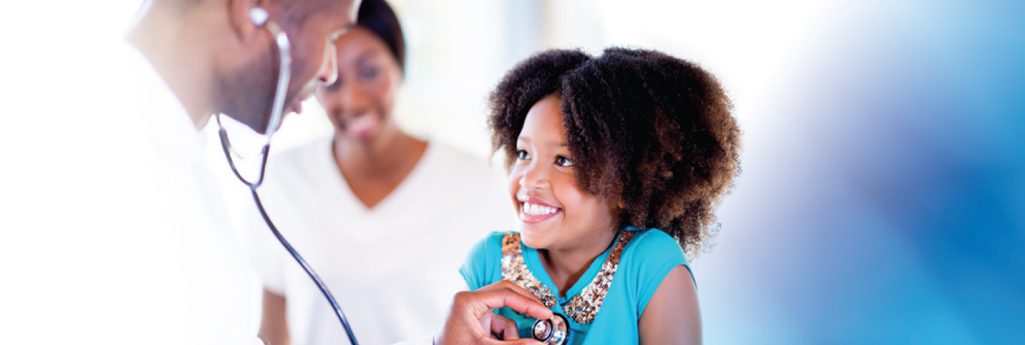 A doctor listens to a girl's heartbeat